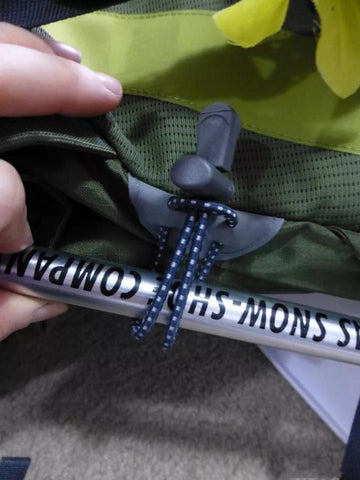 How to fix trekking poles to the backpack?