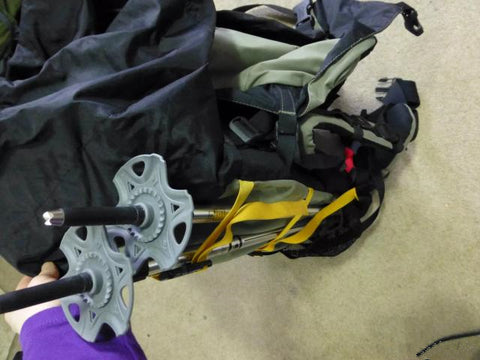 How to fix trekking poles to the backpack?