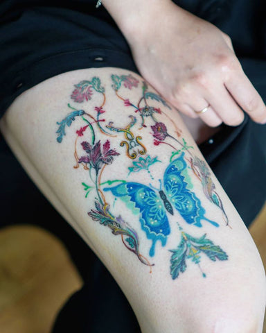 flower and butterfly thigh tattoo