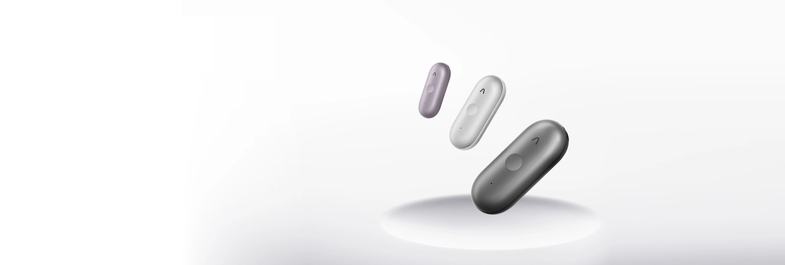 Three Plaud NotePin S AI voice recorders in purple, silver, and gray floating above a white pedestal.
