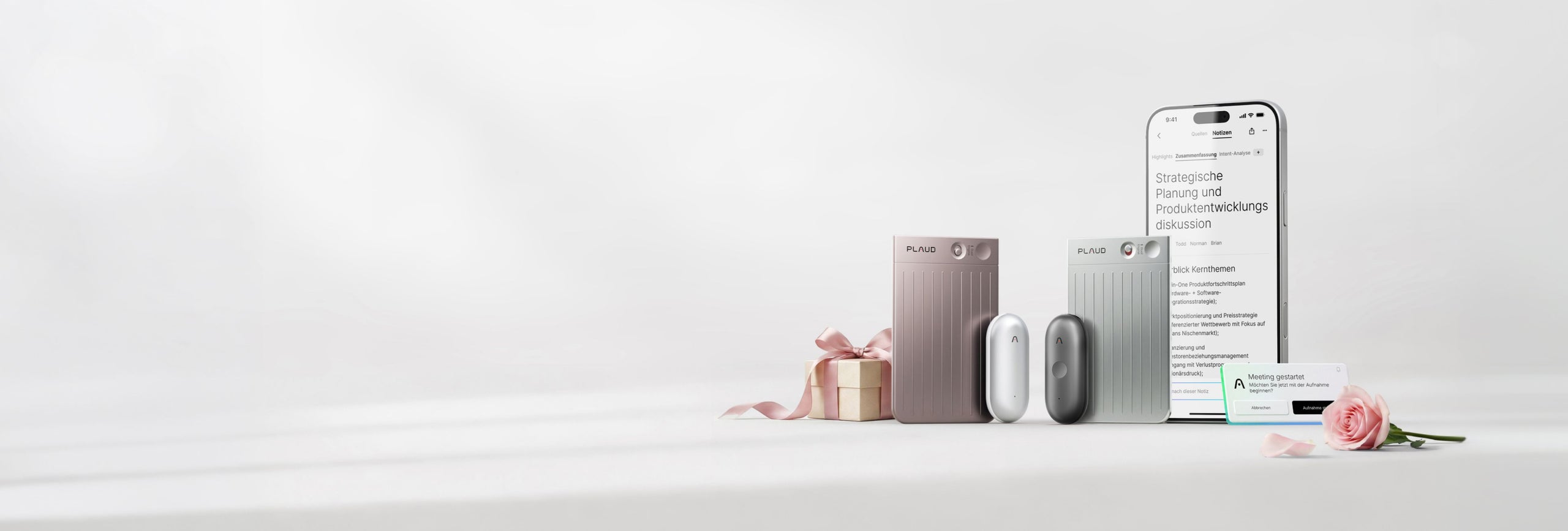 Plaud Note Pro in Rosé und Silber sowie Plaud NotePin in Weiß und Grau neben einem Smartphone mit der Plaud App.