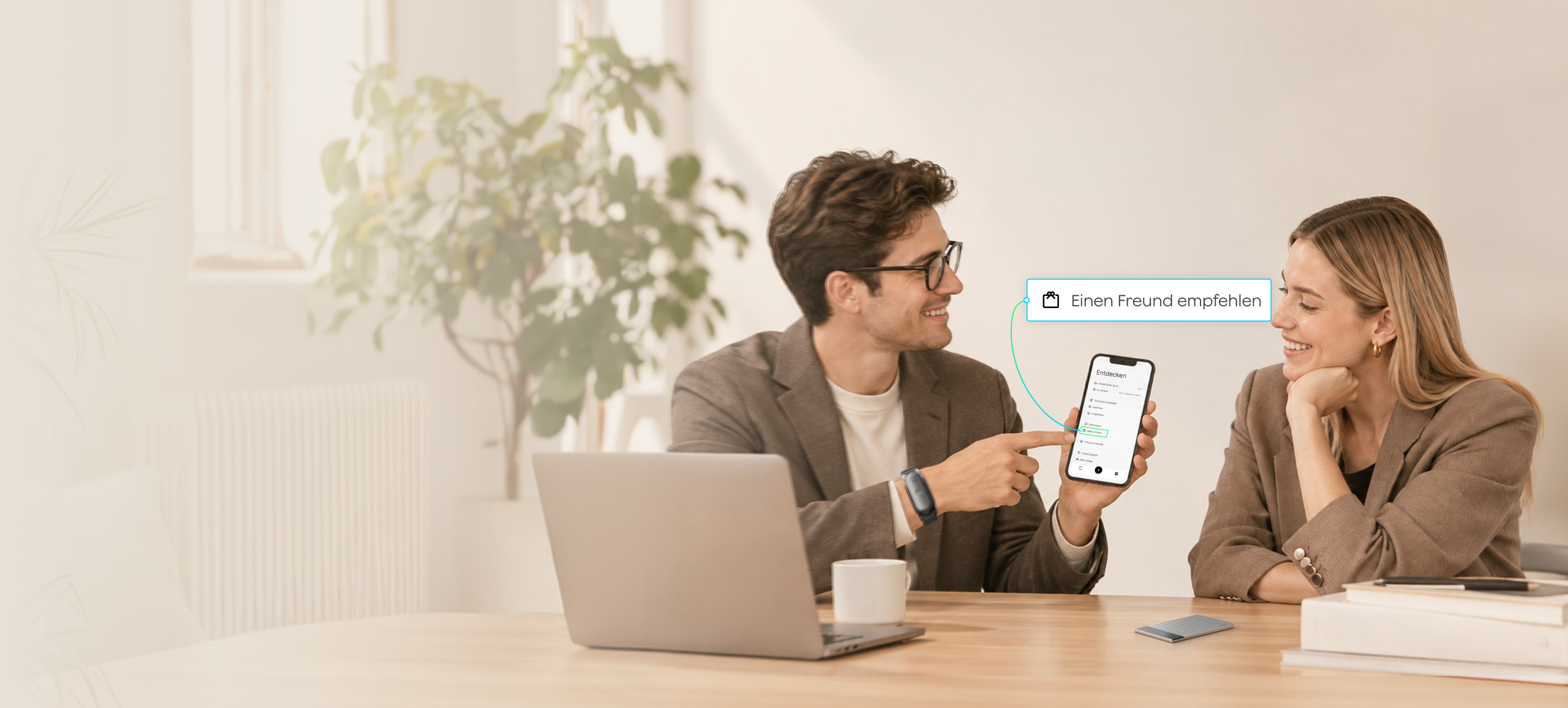 Ein Mann zeigt einer Frau die Option „Einen Freund empfehlen“ in der Plaud App; er trägt einen Plaud NotePin S und ein Plaud Note Pro liegt auf dem Tisch.