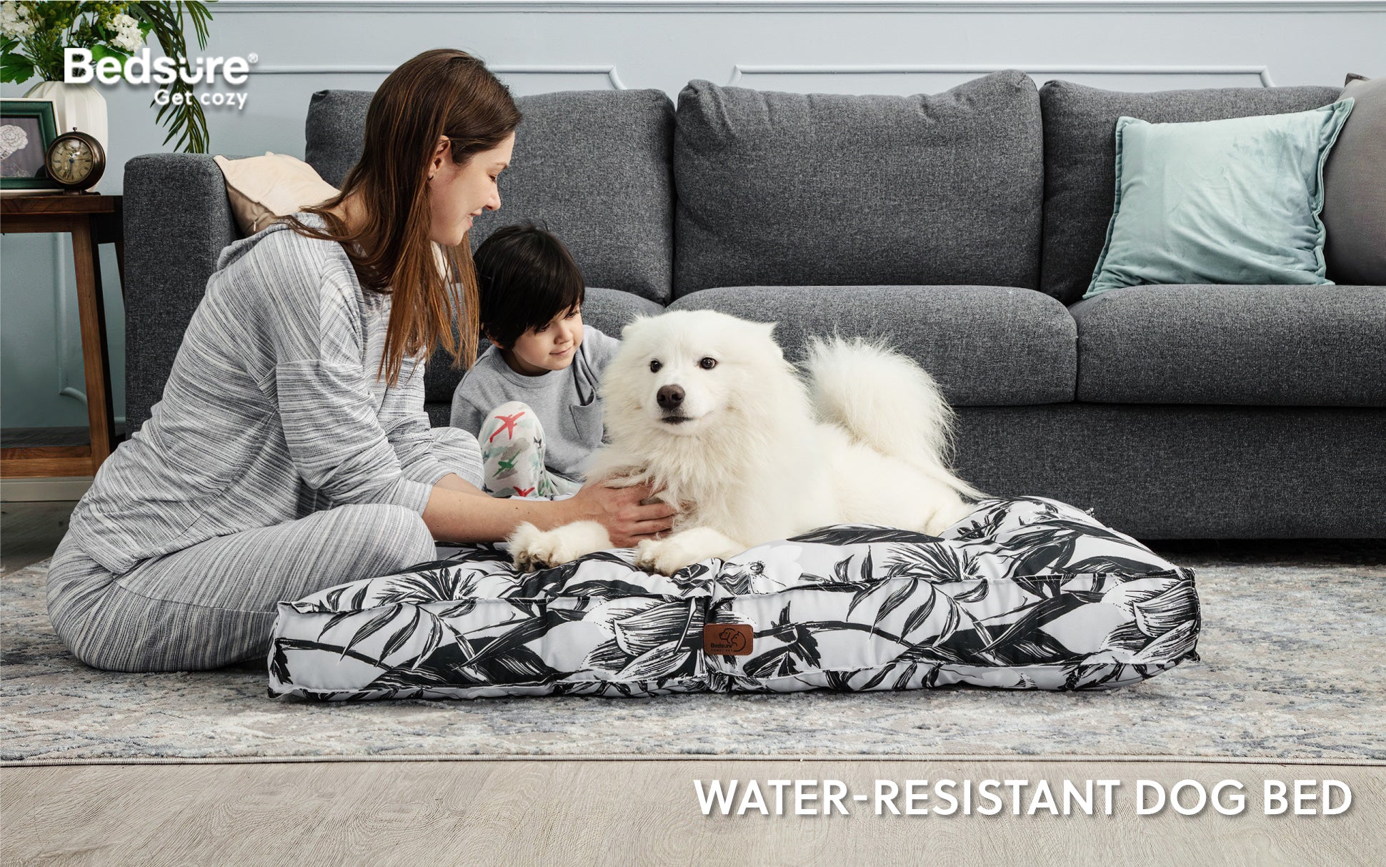 Mum and son sit with their pet dog in Bedsure water-resistant dog bed.