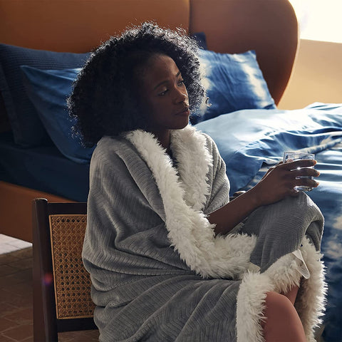 Woman sitting and relaxing with a soft Sherpa Fleece Blanket with Herringbone Pattern Bedsure blanket wrapped around her