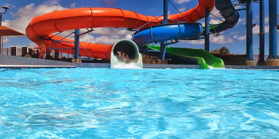 man coming out of a water park slide