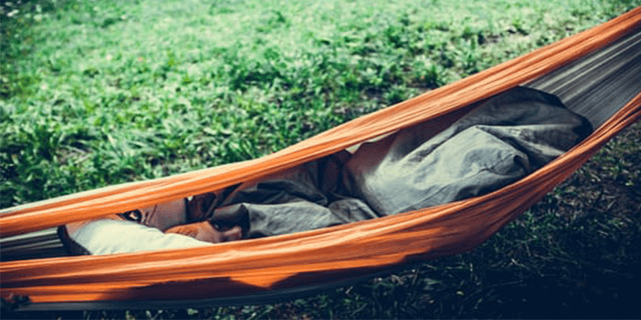 Man sleeping in a camping hammock