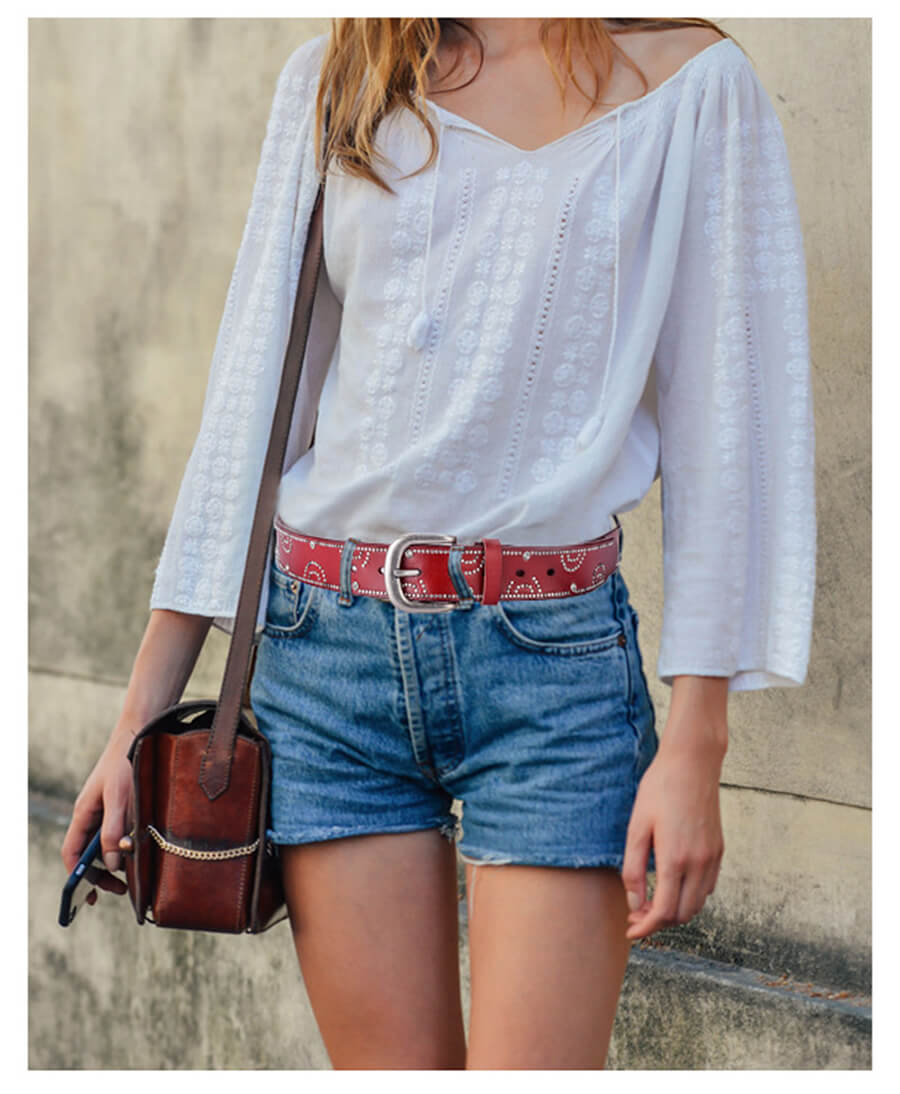 A woman in jean wearing a wine rivet leather belt