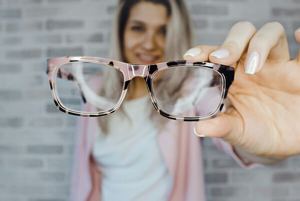 A lady is showing a pair of glasses.