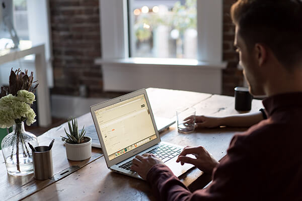 Man typing in front of a computer keyboard