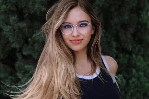 An oval shape beauty is wearing round glasses