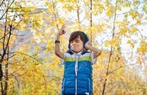 Boy wearing a wristwatch and jamming to music.