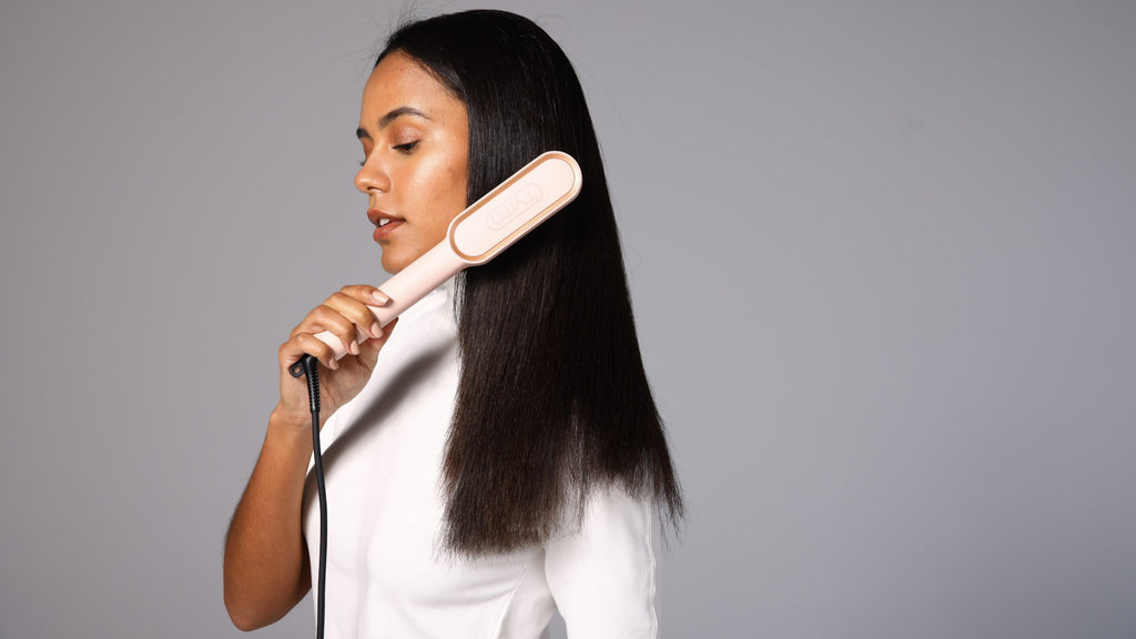 girl uses plug-in hair tool to straighten her hair
