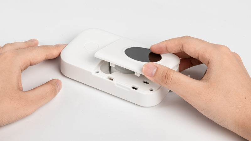 Hand closing the paper compartment of the Phomemo D30 label printer