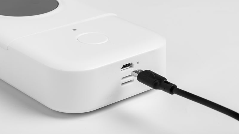 Phomemo D30 label printer charging via USB cable, close-up of power port