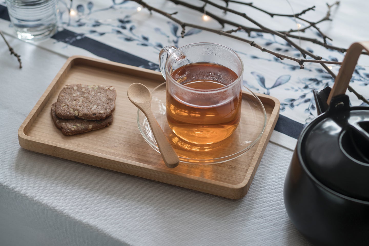竹托盘照片,一杯茶。旁边有一个竹茶匙茶杯,茶壶是只是在盘子的旁边。