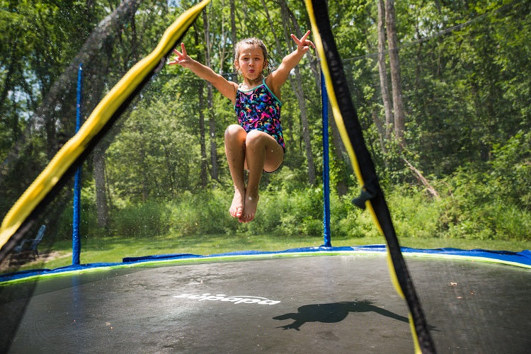 a girl cooling off on a Zupapa backyard trampoline in summer