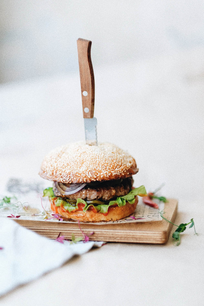 Hamburguesas con ternera servidas sobre tabla de madera