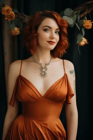 Half-length shot of a Caucasian woman wearing a burnt orange dress and wedding accessories