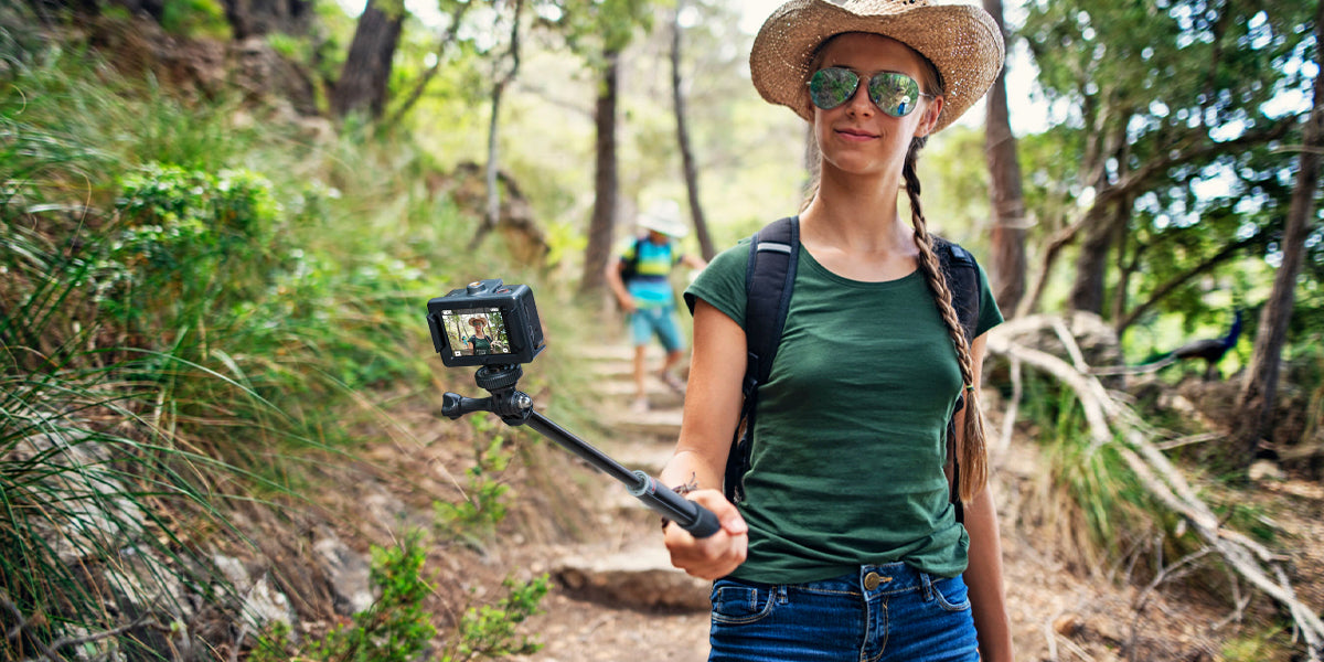 5 Reasons the COOAU-SPC03 Action Camera is the best for Beginners; A woman with an action camera walking in the forest.