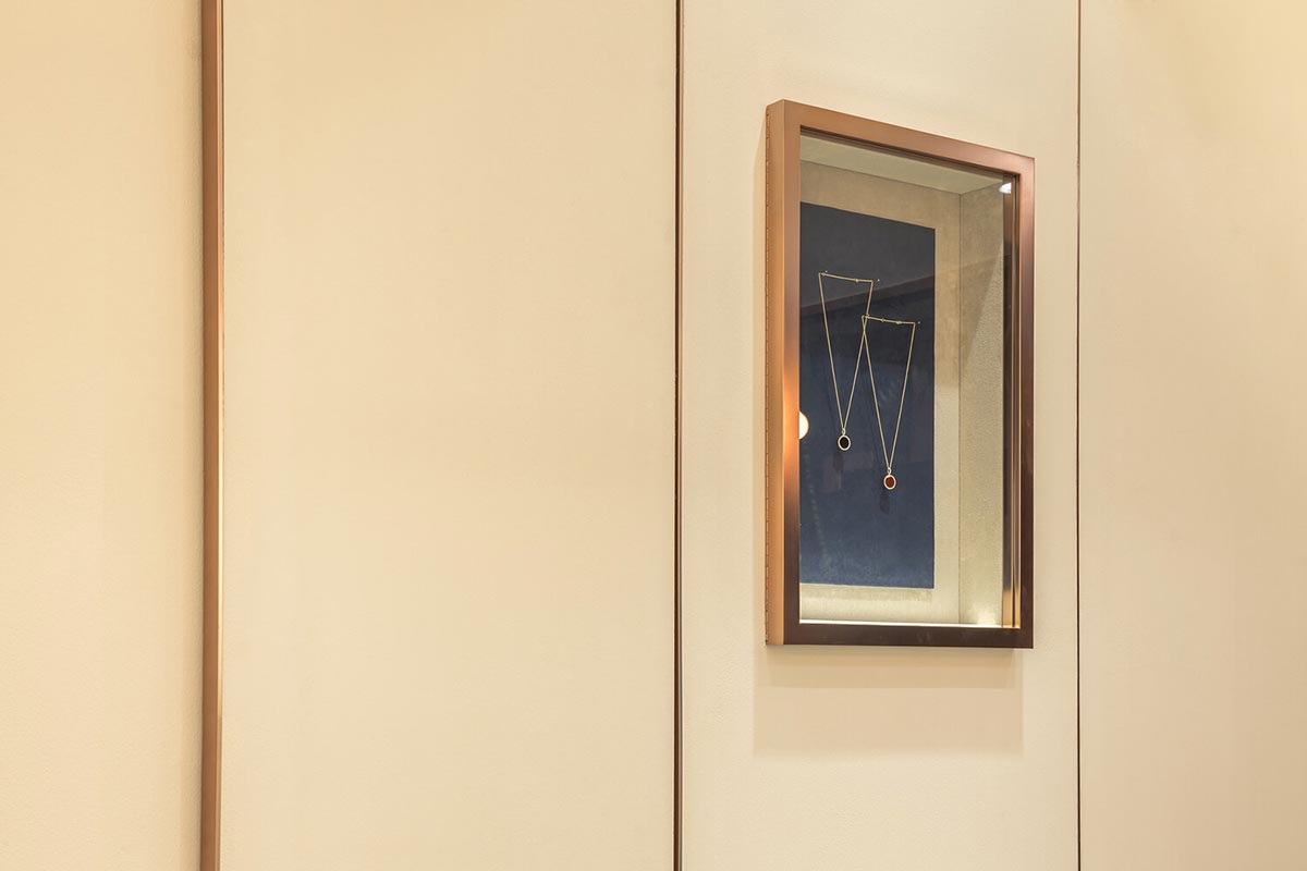 Wall hanging display showing two necklaces