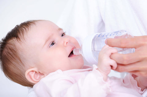 little baby drinking milk from bottle