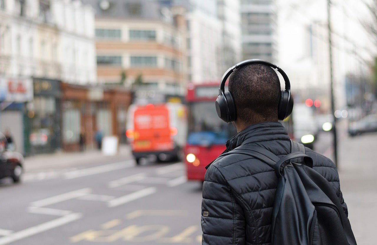 Man using ANC headphones while traveling.