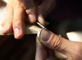 Carving the pattern on the ring with an awl by hand
