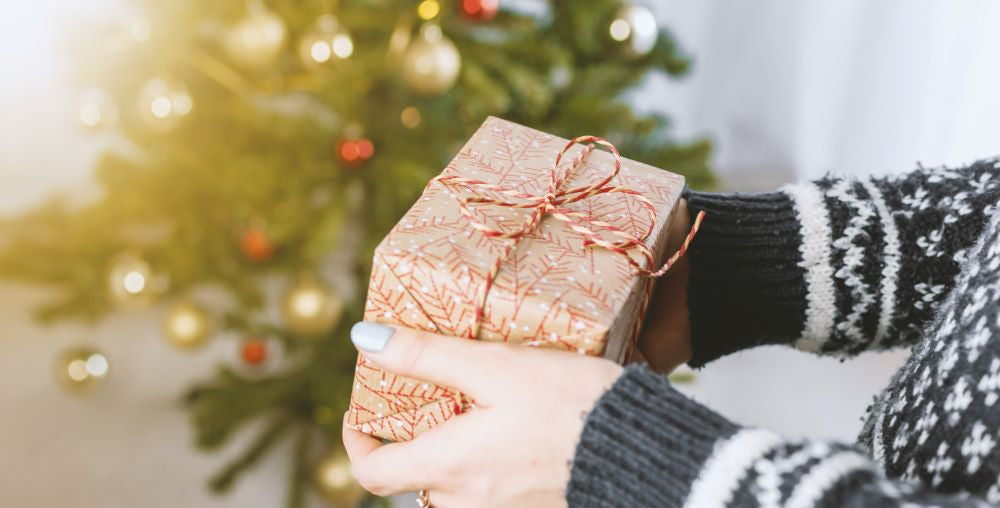 a woman holding a christmas gift box