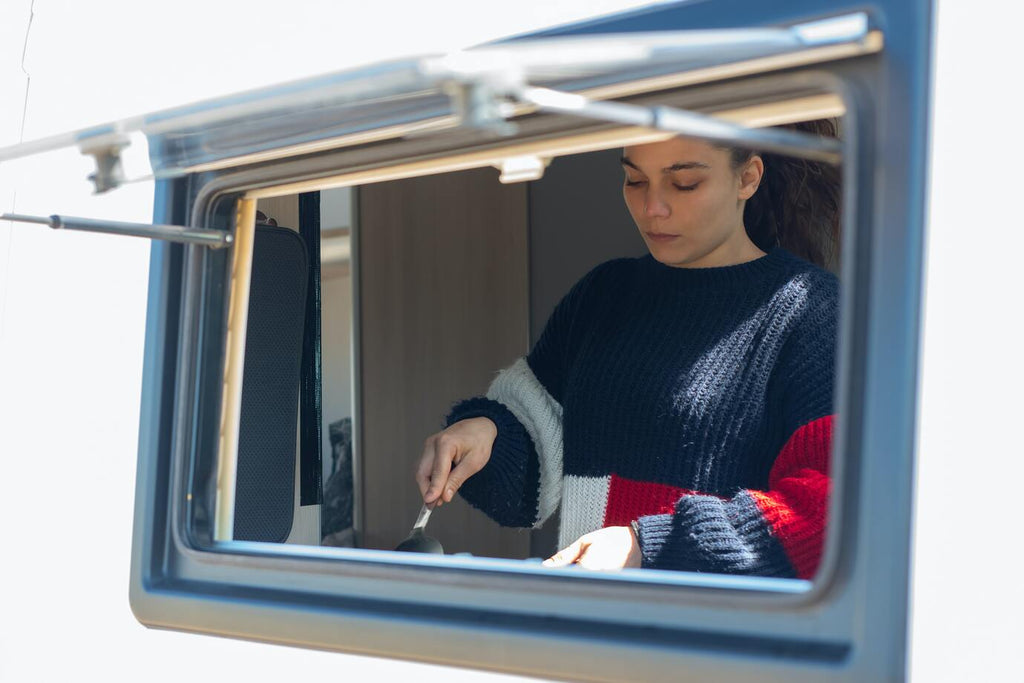 A girl is cooking on an RV 