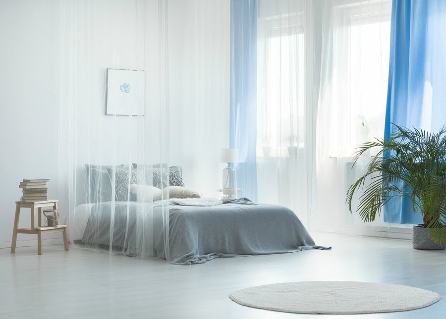 Beautiful White Bed Surrounded by Translucent Sheer Curtains