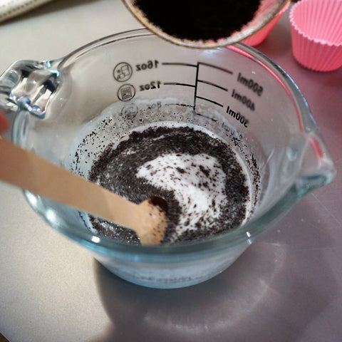 Pour ground coffee into molten soap