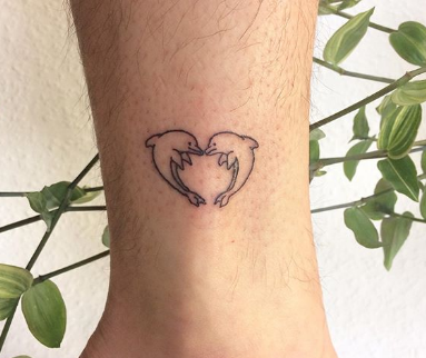 tattoo of heart consist of two dolphins