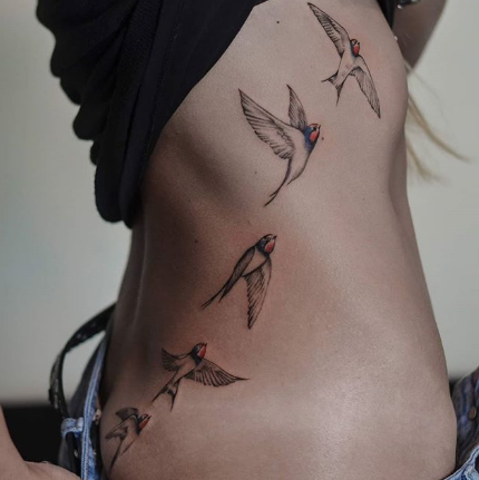 swallow tattoo on the side of the body