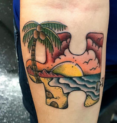 tattoo of beach coconut palm sun ocean in a puzzle piece