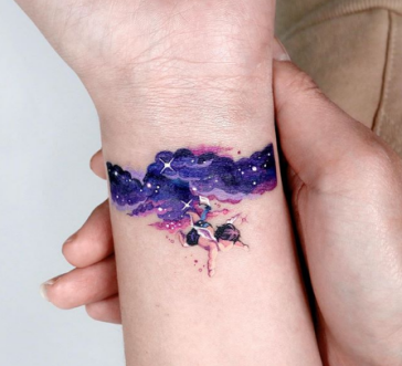 purple blue universe tattoo on the wrist