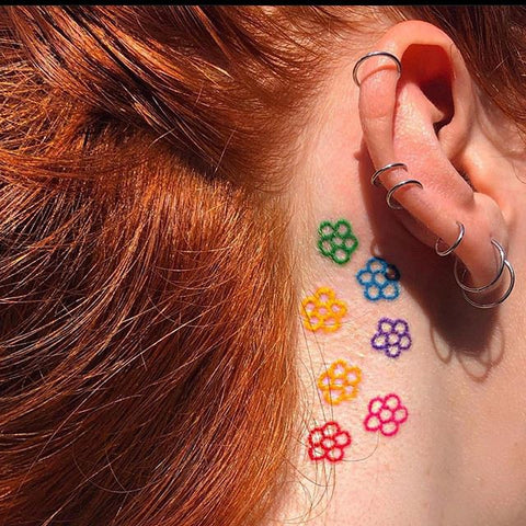 simple flower tattoo after the ear