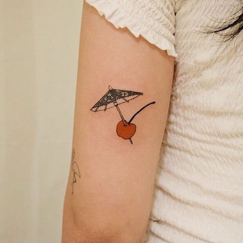 umbrella cherry tattoo on the arm
