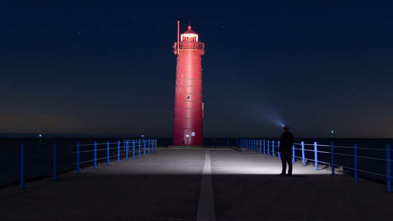 A man wearing the Cyansky LED headlamp looks at the tower.