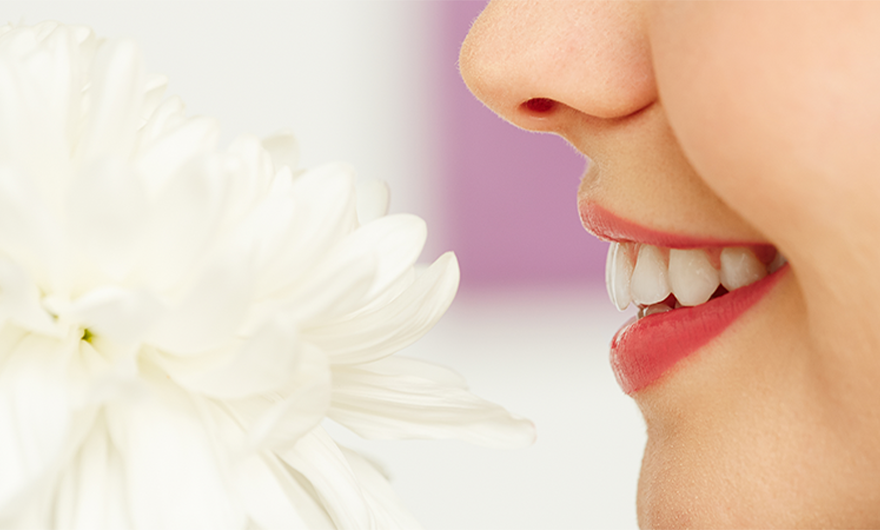 woman smelling white flower smiling