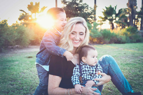 A little boy hugs a woman with a baby