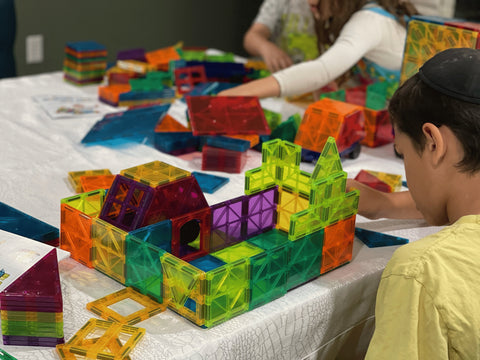 children are playing with magnetic tiles