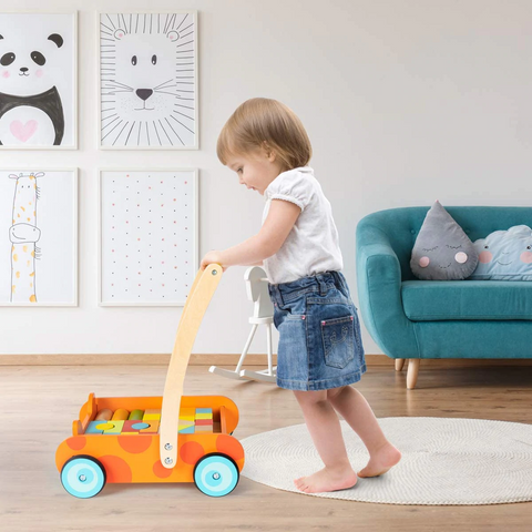 A toddler is using cossy wooden walker car