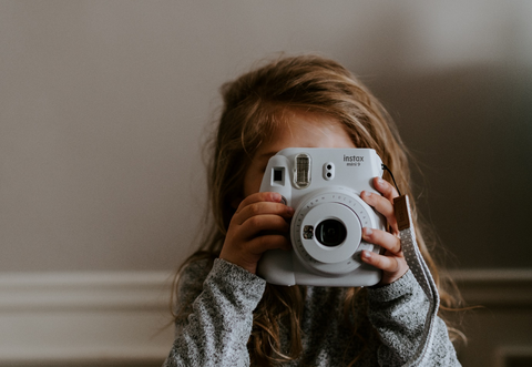 A girl is taking pics with a camera