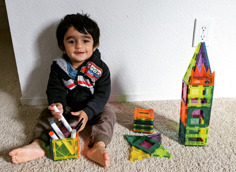 a child built a magnetic tiles tower