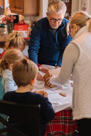 children and their family are building a clay house