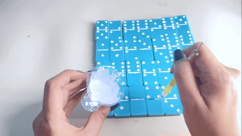 Prepare un poco de mezcla de resina blanca y luego rellene las fichas de dominó.