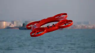 Red rescue drone that looks like a life preserver flies over river