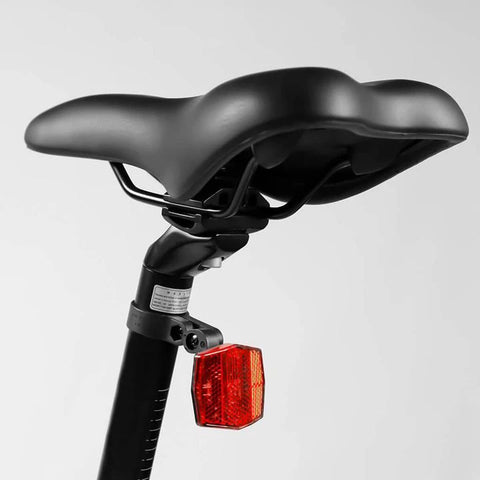 A cyclist adjusting the saddle height on their bicycle.