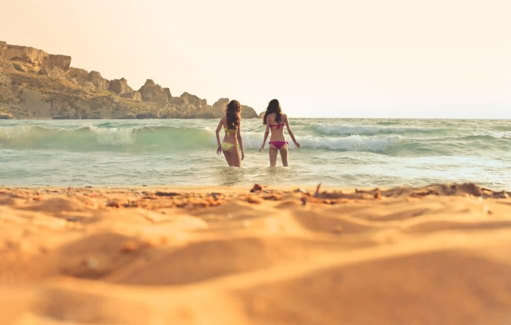 laser hair removal girls walking towards ocean