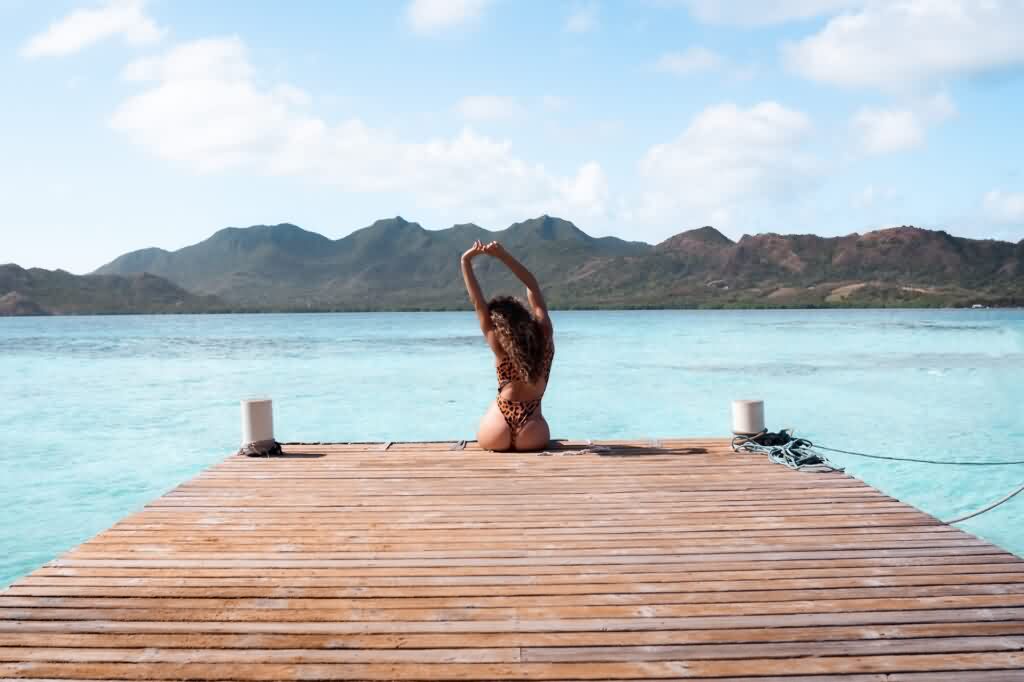 laser hair removal girl sitting on the dock by a lake